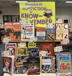 there are many children's books on display at the library table with one sign