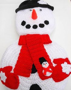 a crocheted snowman with a red scarf