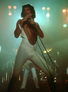 an image of a man that is on stage with his hands in the air and holding a microphone