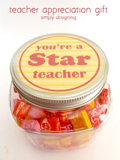 a glass jar filled with candy candies on top of a white table next to a sign that says, you're a star teacher