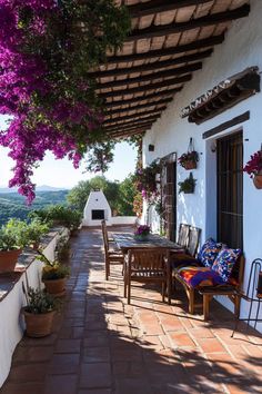 an outdoor patio with tables, chairs and potted plants on the side of it