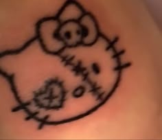 a hello kitty tattoo on the side of a woman's stomach is shown in black ink