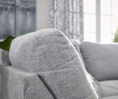 a grey couch sitting next to a window in a living room