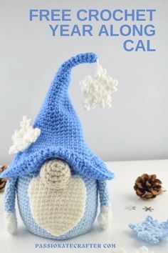 a crocheted blue and white gnome hat with snowflakes on it next to pine cones