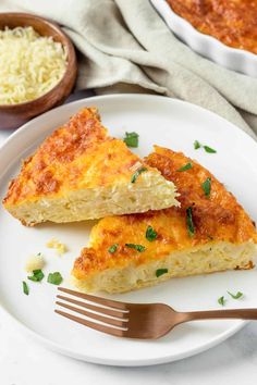 two pieces of cabbage cheese bake on a white plate with a fork next to it