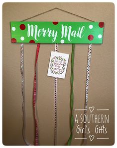 a merry mail sign hanging from the side of a wall next to ribbons and tags