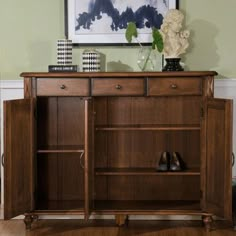 a wooden cabinet with shoes and vases on top