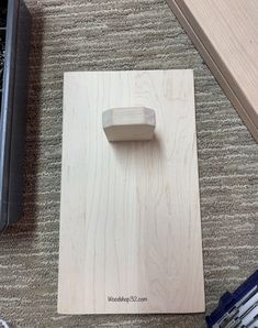 a wood block with a wooden handle sitting on the floor next to other tools and supplies