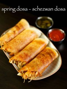 three spring rolls on a plate with dipping sauce