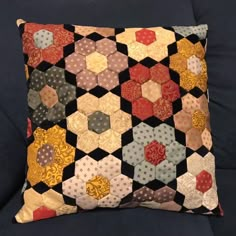 a black couch with a colorful patchwork pillow on it