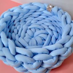 a blue ring is sitting on top of a large braided object that looks like something out of space