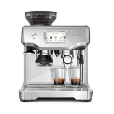 an espresso machine with two cups on the side and one cup full of coffee