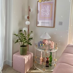 a living room filled with furniture and a pink couch next to a painting on the wall