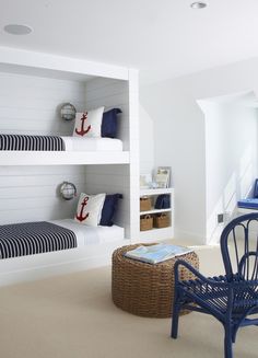 a room with two bunk beds and a blue chair in the corner next to it