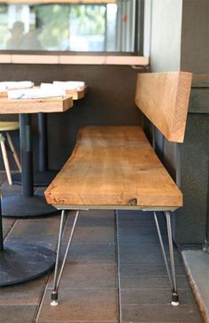 two wooden chairs sitting next to each other on top of a tiled floor in front of a window