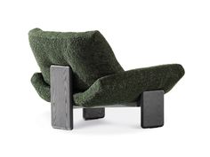 a green chair sitting on top of a wooden block