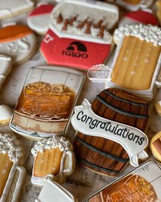 decorated cookies with congratulationss on them sitting on a table next to wine glasses and other items