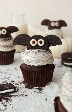 cupcakes decorated with chocolate frosting and googly eyes are sitting on a table