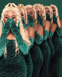 lady in green dress covering her face with hands while standing next to other women wearing matching dresses