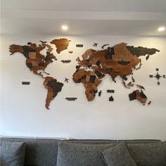 a living room with a couch and a large wooden world map mounted on the wall