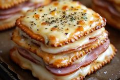 there are crackers stacked on top of each other with cheese and meat in them