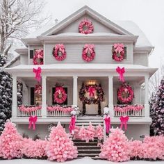 a house decorated for christmas with wreaths and pink decorations