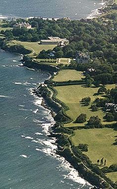 an aerial view of a golf course near the ocean with houses and trees on it