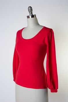 Introducing the Grace Top, a timelessly chic cotton knit piece with a scoopy neck and bishop sleeve, for a versatile wardrobe addition. Crafted from soft, durable fabric, this top offers exemplary comfort and all-day wearability. Plus, its classic color ensures you can style the Grace Top in a variety of ways. Jersey Knit - 95Cotton/5Spandex blend Scoopy Neckine Bishop Sleeve Fall Red Elastane Tops, Stretch Puff Sleeve Solid Color Top, Solid Color Stretch Puff Sleeve Top, Stretch Solid Color Puff Sleeve Top, Stretch Long Sleeve Scoop Neck Top In Solid Color, Fitted Long Sleeve Scoop Neck Top, Fitted Long Sleeve Top With Scoop Neck, Solid Color Stretch Long Sleeve Top With Scoop Neck, Solid Stretch Long Sleeve Top With Scoop Neck