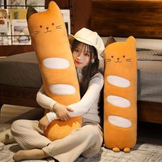 a woman is sitting on the floor with two large stuffed cats in front of her