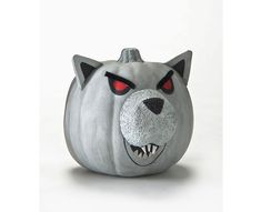 a gray pumpkin with red eyes and a cat's face painted on it is shown