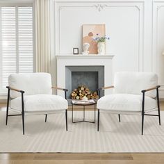 two white chairs sitting in front of a fire place next to a table with logs on it