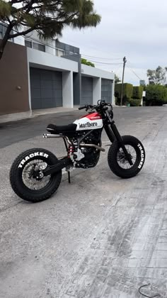 a black and white motorcycle parked on the side of a road next to a building