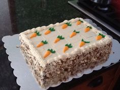 a cake with carrots on it sitting on top of a table next to a stove