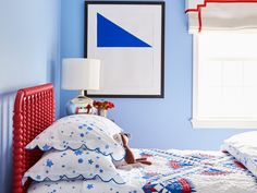 a bedroom with blue walls and red bedding