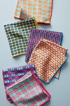 four napkins with different patterns on them, one is blue and the other is orange