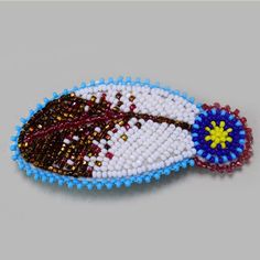 a beaded brooch with an image of a football on it's side