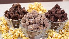 three cups filled with chocolate popcorn on top of a table