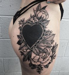 a woman's thigh with flowers and a heart tattoo on the side of her thighs