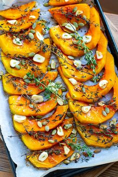 roasted pumpkins with herbs and almonds on a baking sheet