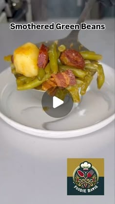 a white plate topped with green beans and bacon