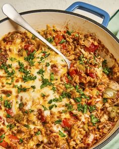 a skillet filled with meat and vegetables covered in cheese