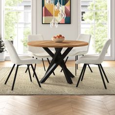 a dining room table with four chairs and a bowl of fruit on the center piece