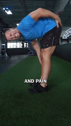 a man in blue shirt and black shorts doing push ups on green carpeted floor