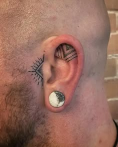 a man's ear with tattoos on it