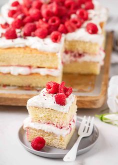 a piece of cake with white frosting and raspberries on top