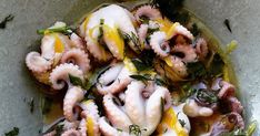 an octopus dish with lemon slices and herbs