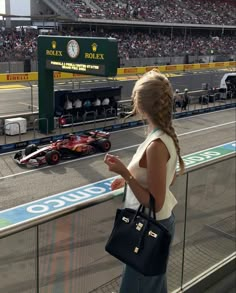 a woman standing in front of a race track