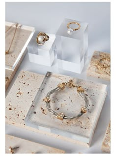 three pieces of jewelry sitting on top of each other in front of some white boxes