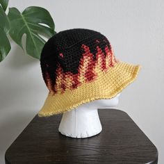 a crocheted hat sitting on top of a wooden table next to a potted plant