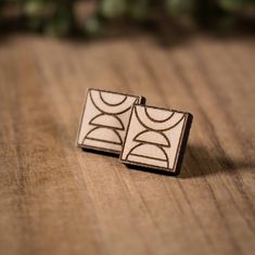 two wooden cufflinks sitting on top of a table